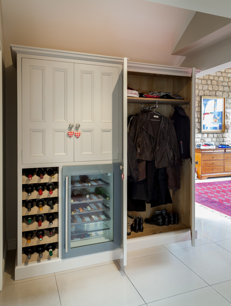 Modelo de armario y vestidor unisex de estilo de casa de campo con armarios con paneles empotrados y puertas de armario blancas