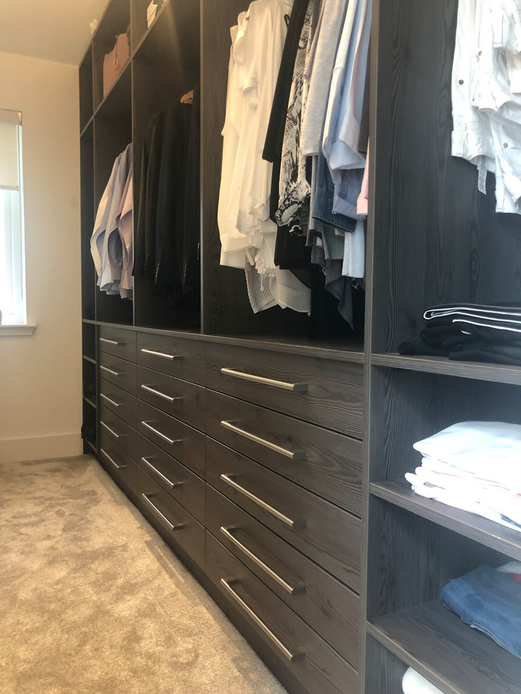 Foto de armario vestidor unisex actual de tamaño medio con armarios abiertos, puertas de armario de madera en tonos medios, moqueta y suelo gris