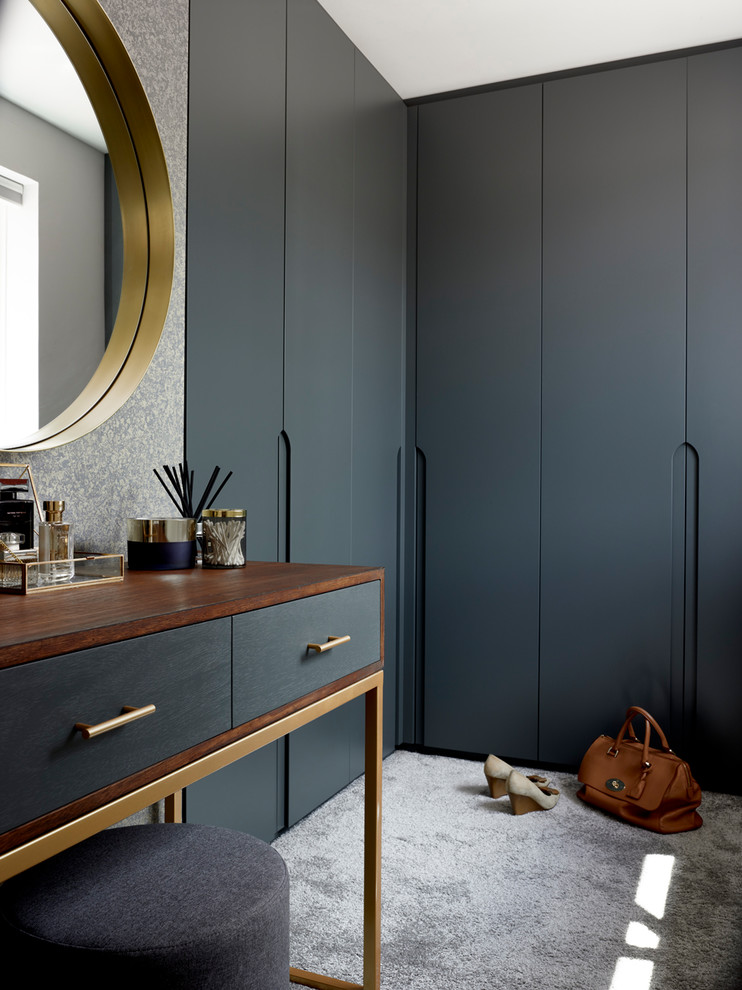 Immagine di uno spazio per vestirsi unisex minimalista con ante lisce, ante grigie, moquette e pavimento grigio