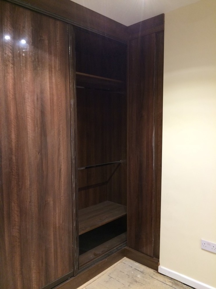 Ejemplo de armario unisex contemporáneo de tamaño medio con armarios tipo vitrina, puertas de armario de madera en tonos medios y suelo de madera clara