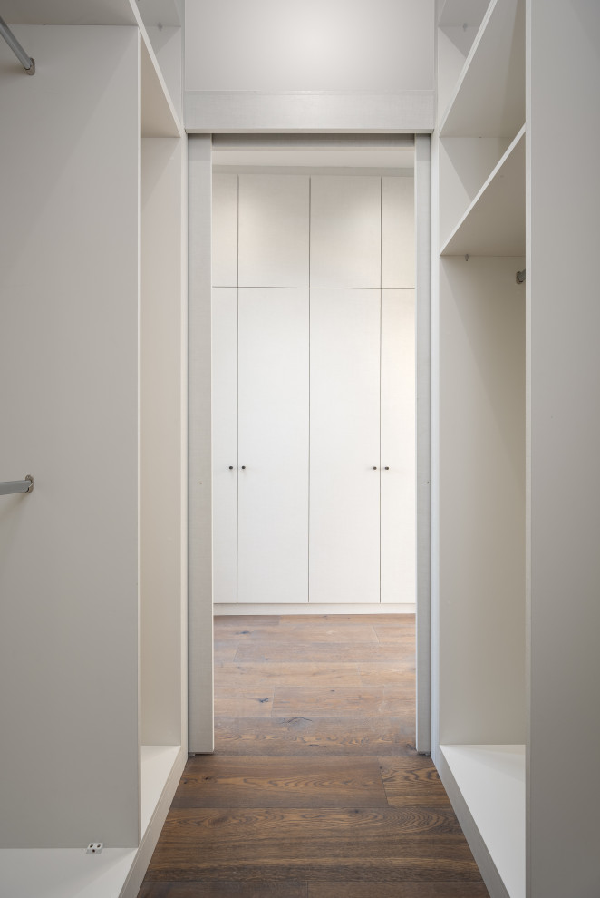 Kleines, Neutrales Modernes Ankleidezimmer mit Einbauschrank, flächenbündigen Schrankfronten, grauen Schränken und braunem Boden in London