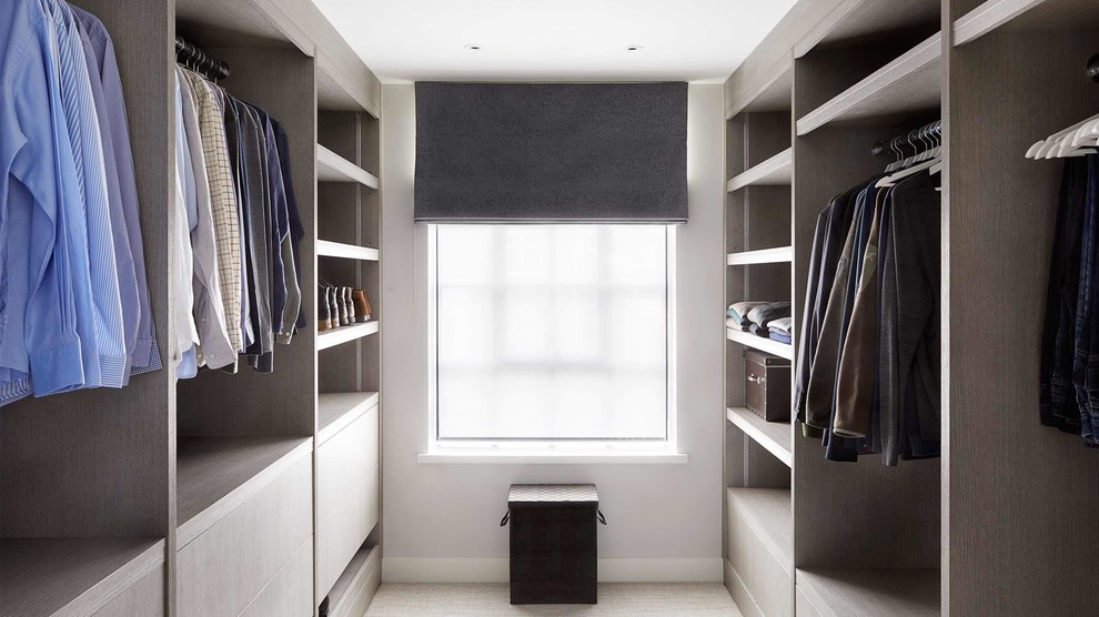 Ejemplo de armario vestidor de hombre moderno de tamaño medio con armarios con paneles lisos, puertas de armario grises, moqueta y suelo gris
