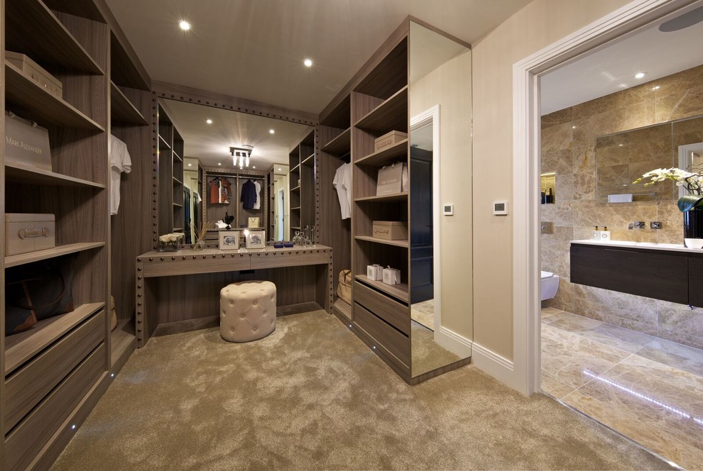 Trendy gender-neutral carpeted walk-in closet photo in Hertfordshire with open cabinets and light wood cabinets