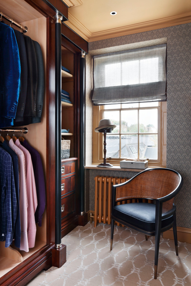 Aménagement d'un petit dressing room classique en bois brun pour un homme avec un placard sans porte, moquette et un sol beige.