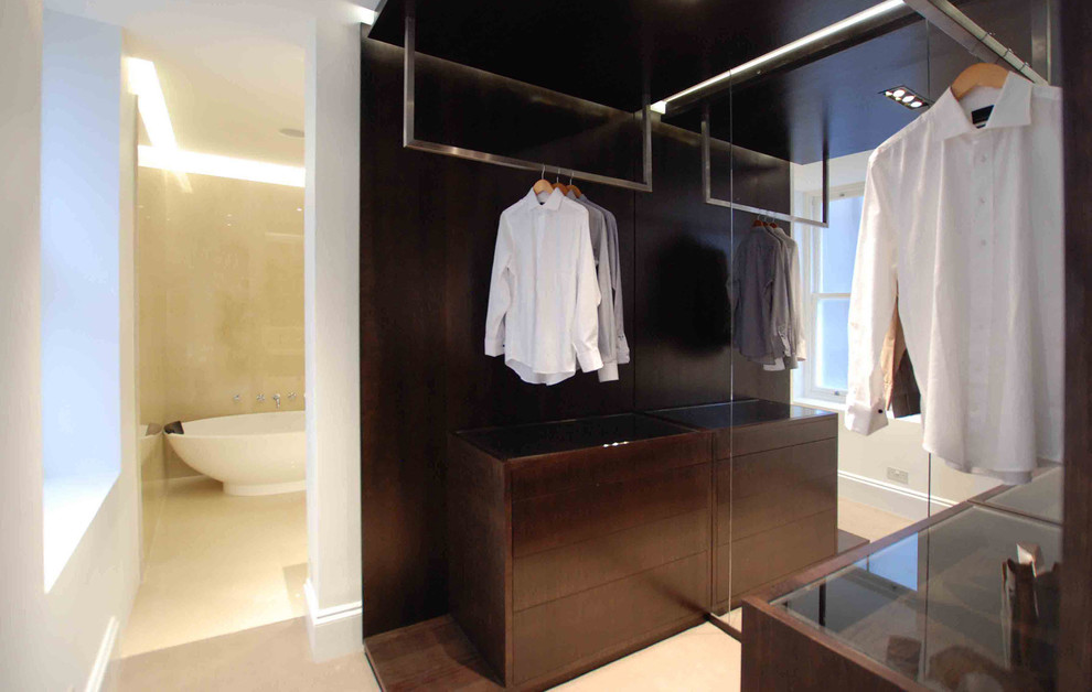 Foto di uno spazio per vestirsi per uomo design di medie dimensioni con ante lisce, ante in legno bruno e moquette
