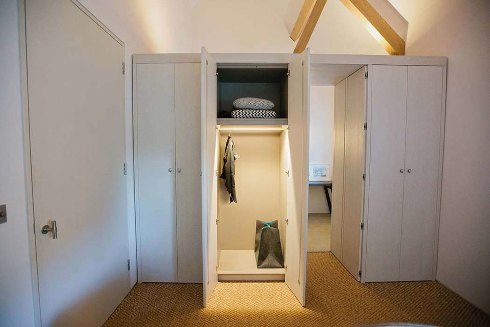 EIngebautes, Mittelgroßes, Neutrales Modernes Ankleidezimmer mit flächenbündigen Schrankfronten, weißen Schränken und Teppichboden in Devon