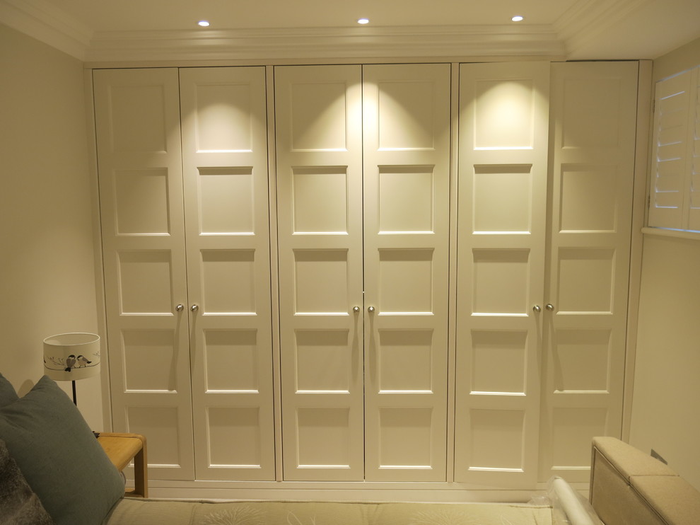 Foto de vestidor unisex contemporáneo grande con armarios con paneles con relieve y puertas de armario blancas