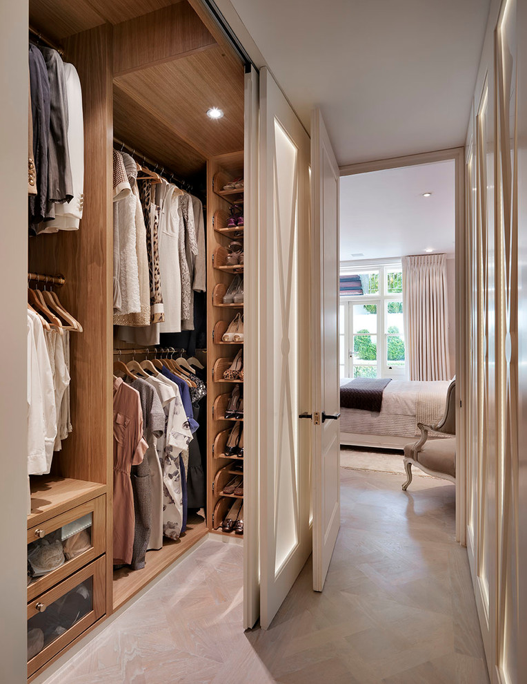 Inspiration for a large victorian walk-in wardrobe for women in London with open cabinets and light wood cabinets.