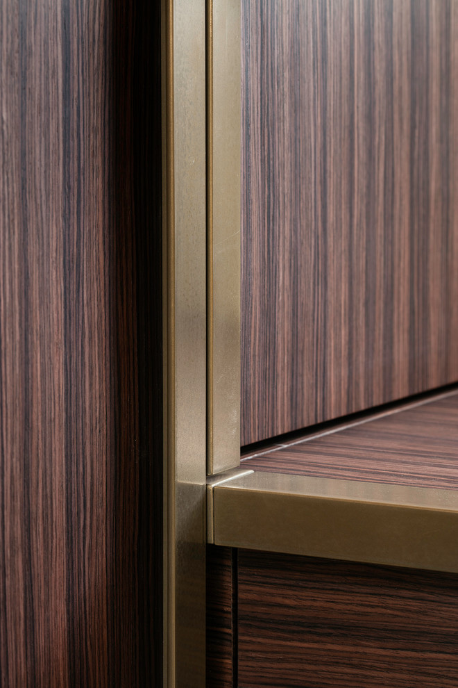 Immagine di un piccolo spazio per vestirsi unisex design con ante lisce e ante in legno bruno