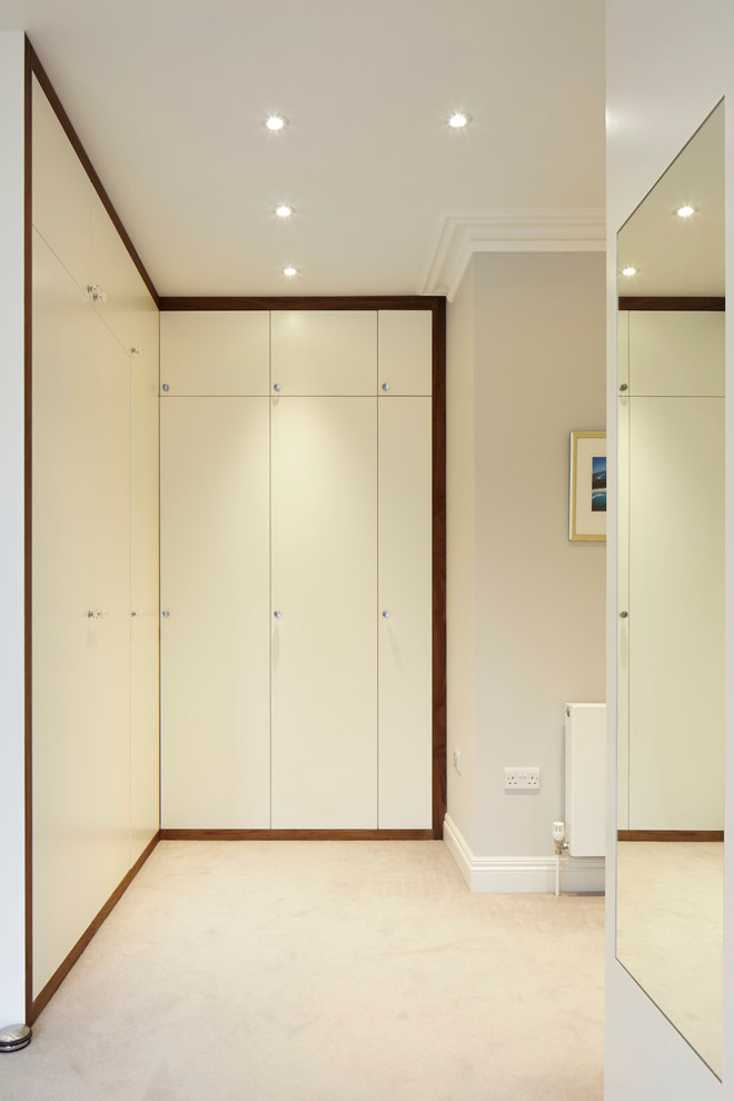Design ideas for a traditional dressing room in London with flat-panel cabinets.