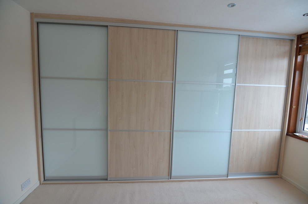 Diseño de armario minimalista grande con armarios tipo vitrina y puertas de armario de madera clara
