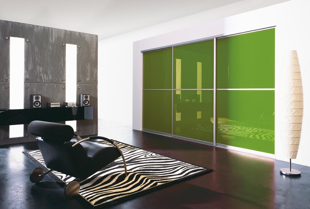 Foto di un grande armadio o armadio a muro unisex minimal con ante di vetro, ante verdi e parquet scuro
