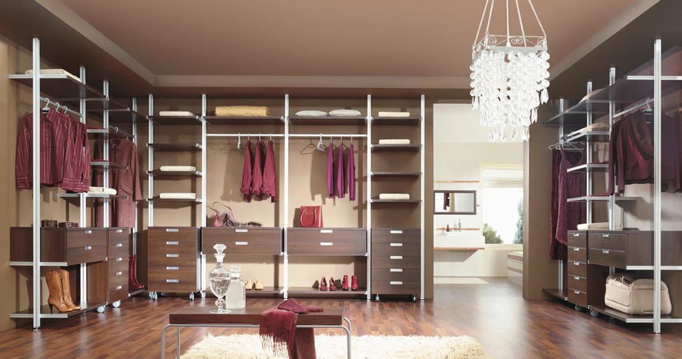 Design ideas for a large contemporary gender neutral walk-in wardrobe in Glasgow with open cabinets, brown cabinets and dark hardwood flooring.