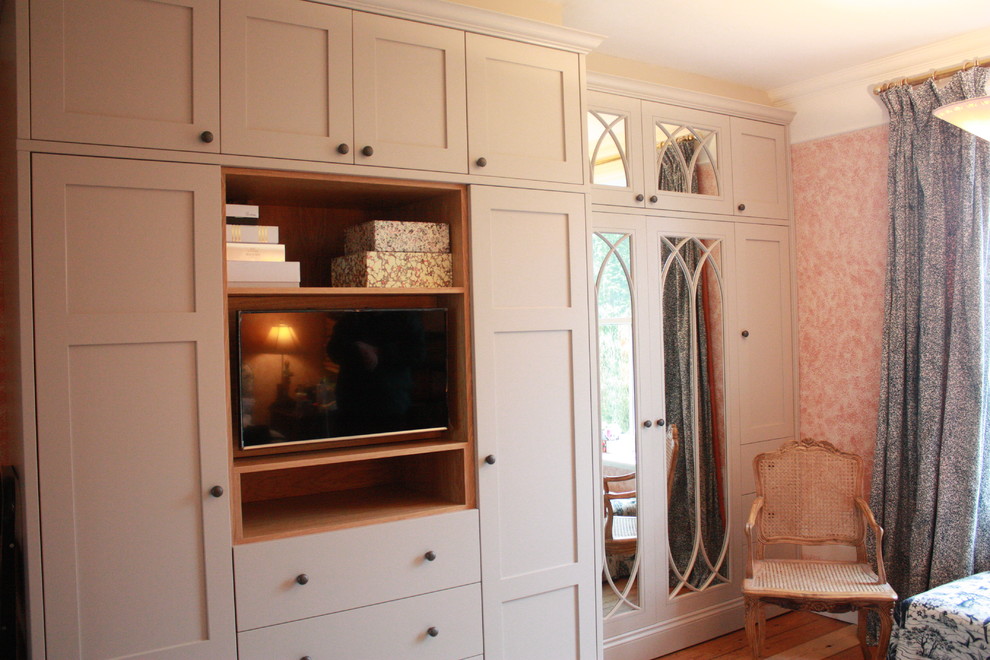 Imagen de armario unisex clásico extra grande con armarios estilo shaker, suelo de madera en tonos medios y puertas de armario grises