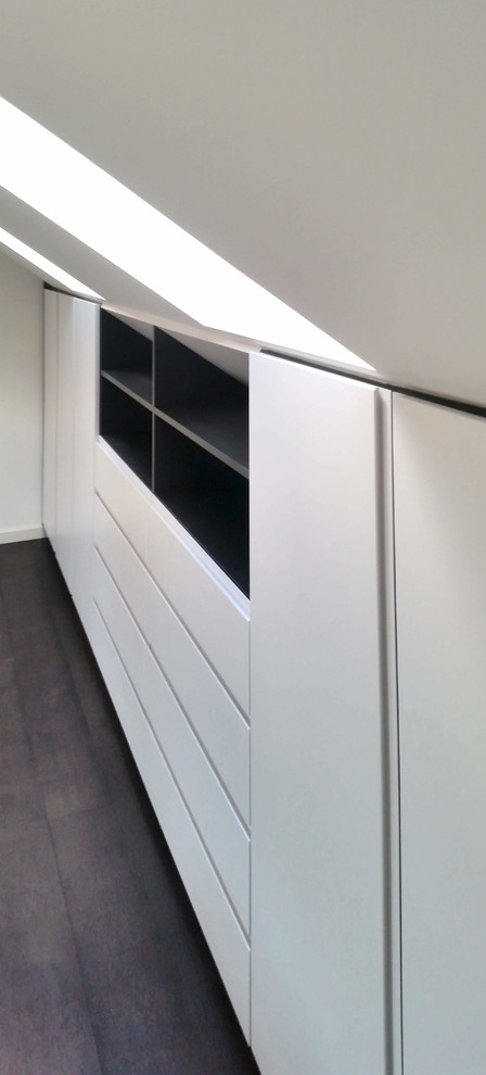 Esempio di armadi e cabine armadio minimalisti di medie dimensioni con ante bianche, pavimento in laminato e pavimento nero