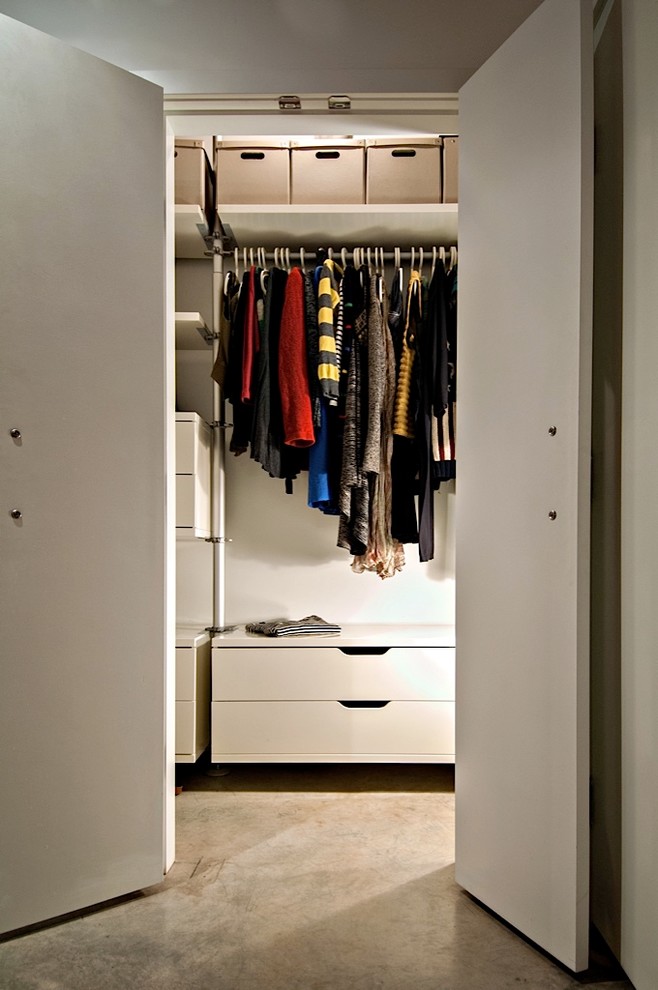 Inspiration för ett litet eklektiskt walk-in-closet för könsneutrala, med släta luckor, vita skåp och betonggolv