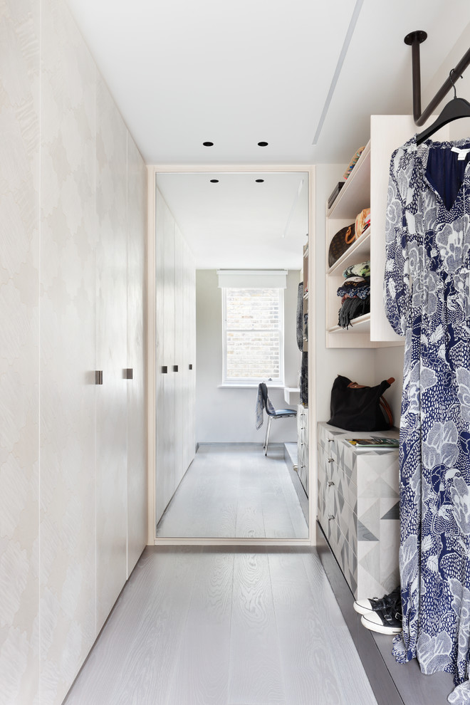 Foto di una cabina armadio unisex minimalista di medie dimensioni con ante lisce, ante in legno chiaro e pavimento grigio