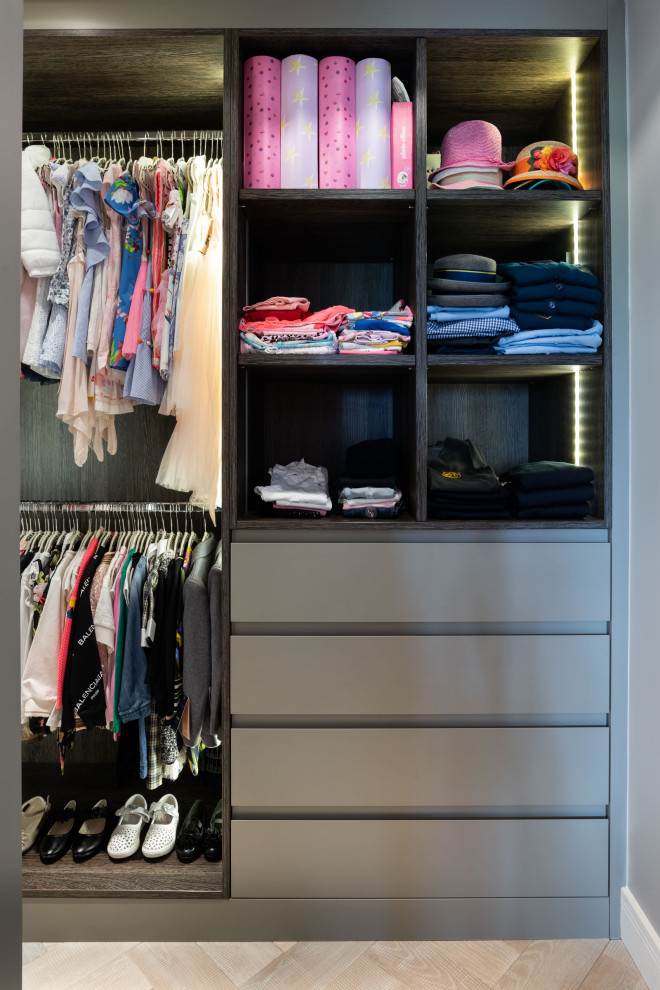 Design ideas for a small contemporary gender neutral walk-in wardrobe in London with open cabinets, dark wood cabinets, light hardwood flooring and beige floors.
