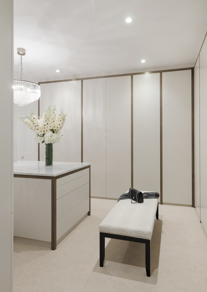 This is an example of a large contemporary wardrobe in Other with beige floors and carpet.