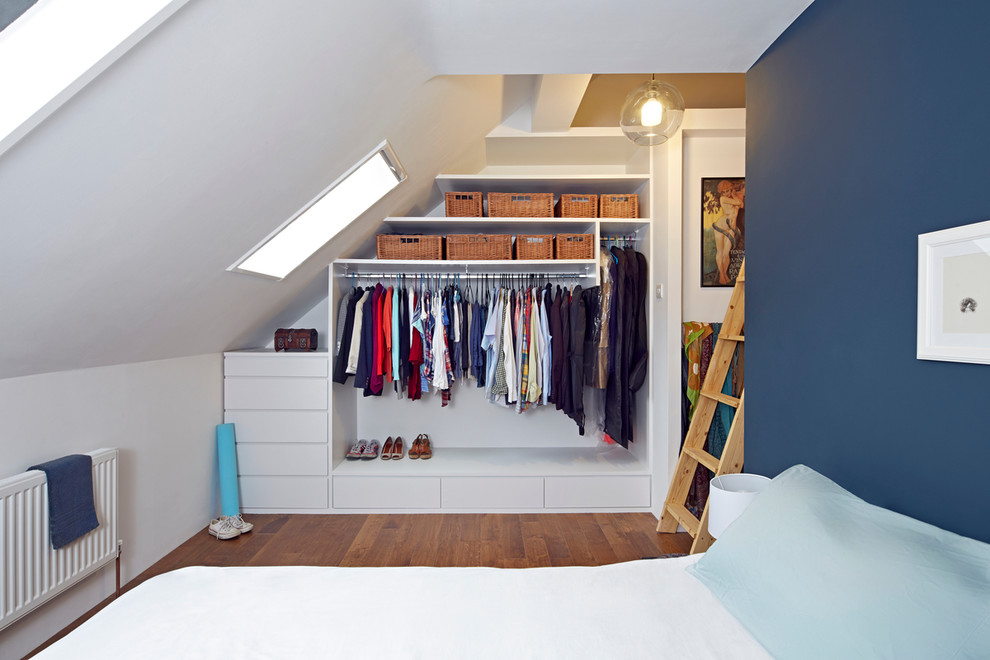 Small contemporary wardrobe in London with medium hardwood flooring.
