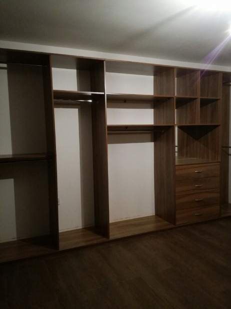 Idee per una grande cabina armadio unisex minimalista con nessun'anta e ante in legno bruno
