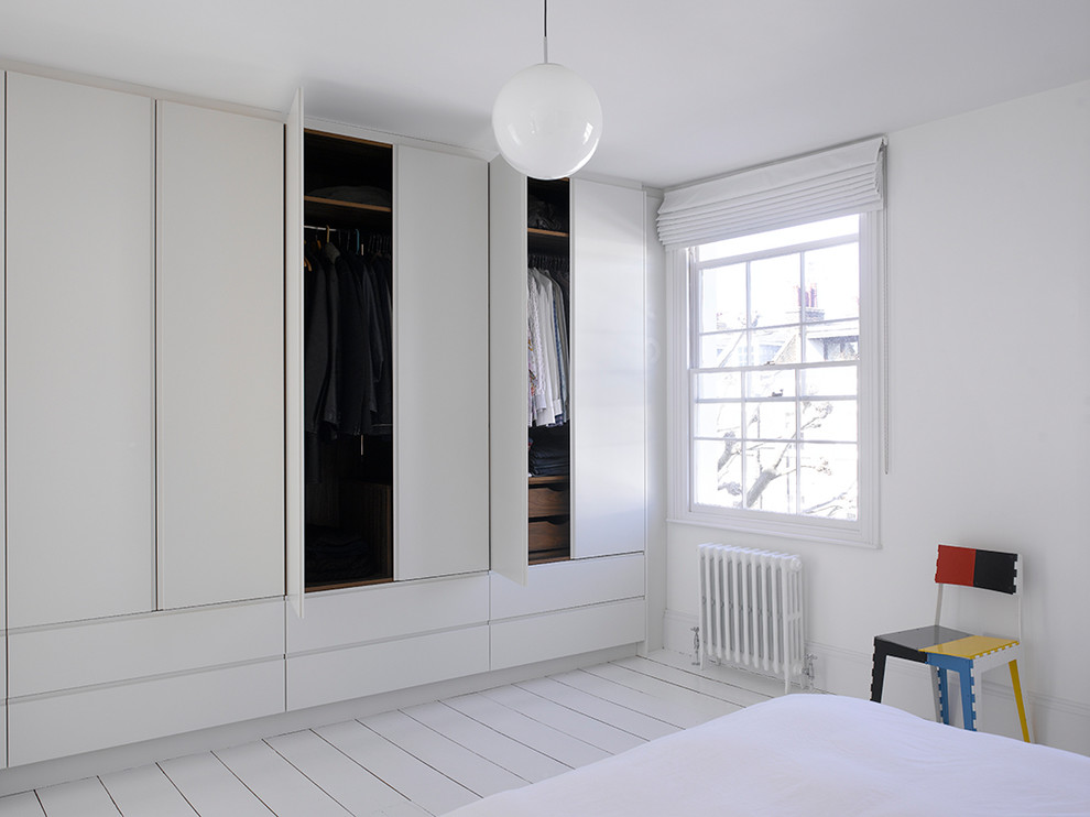 Свежая идея для дизайна: большой шкаф в нише унисекс в современном стиле с плоскими фасадами, белыми фасадами, деревянным полом и белым полом - отличное фото интерьера