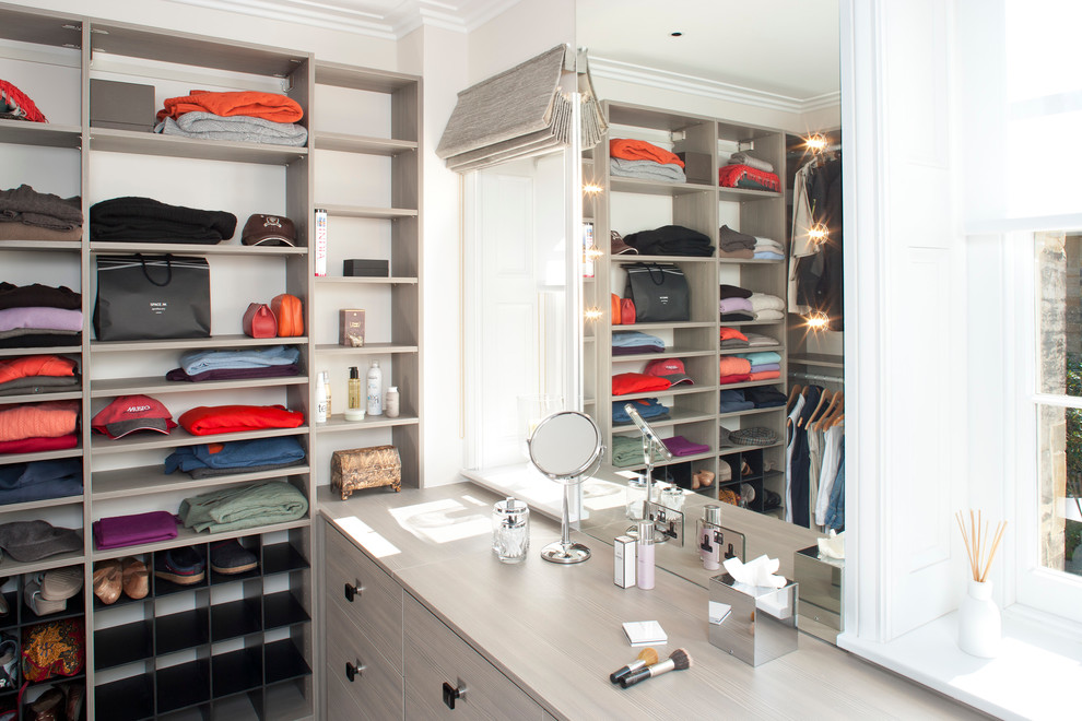 Contemporary walk-in wardrobe in London with grey cabinets.