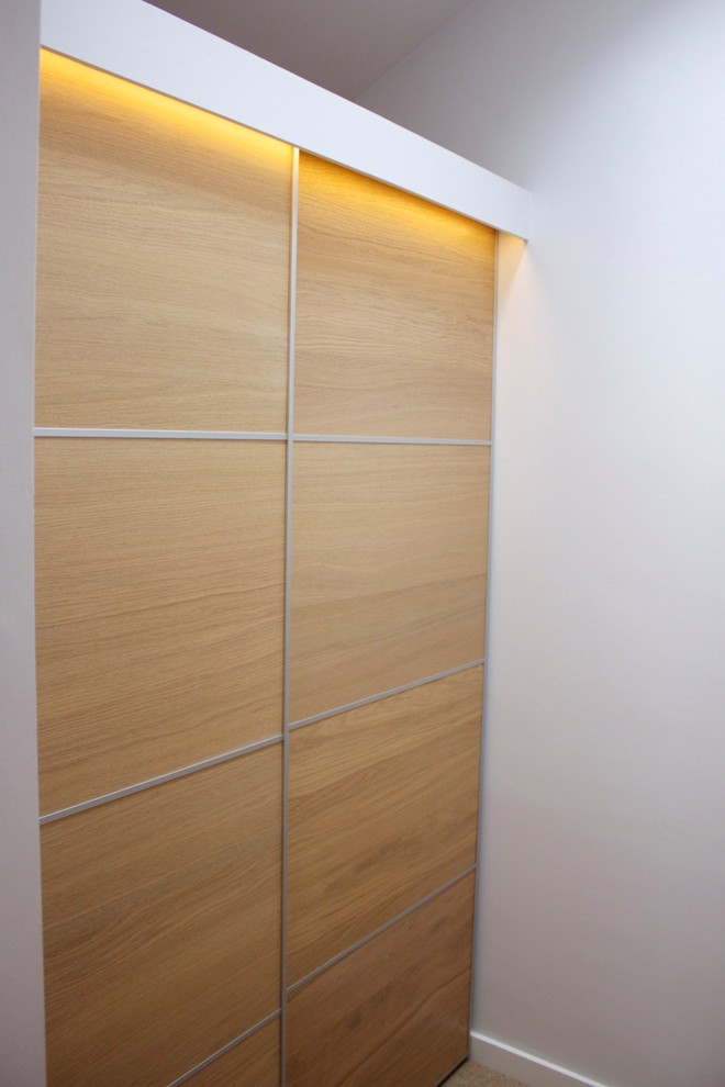 Réalisation d'un dressing room minimaliste en bois brun de taille moyenne et neutre avec moquette.