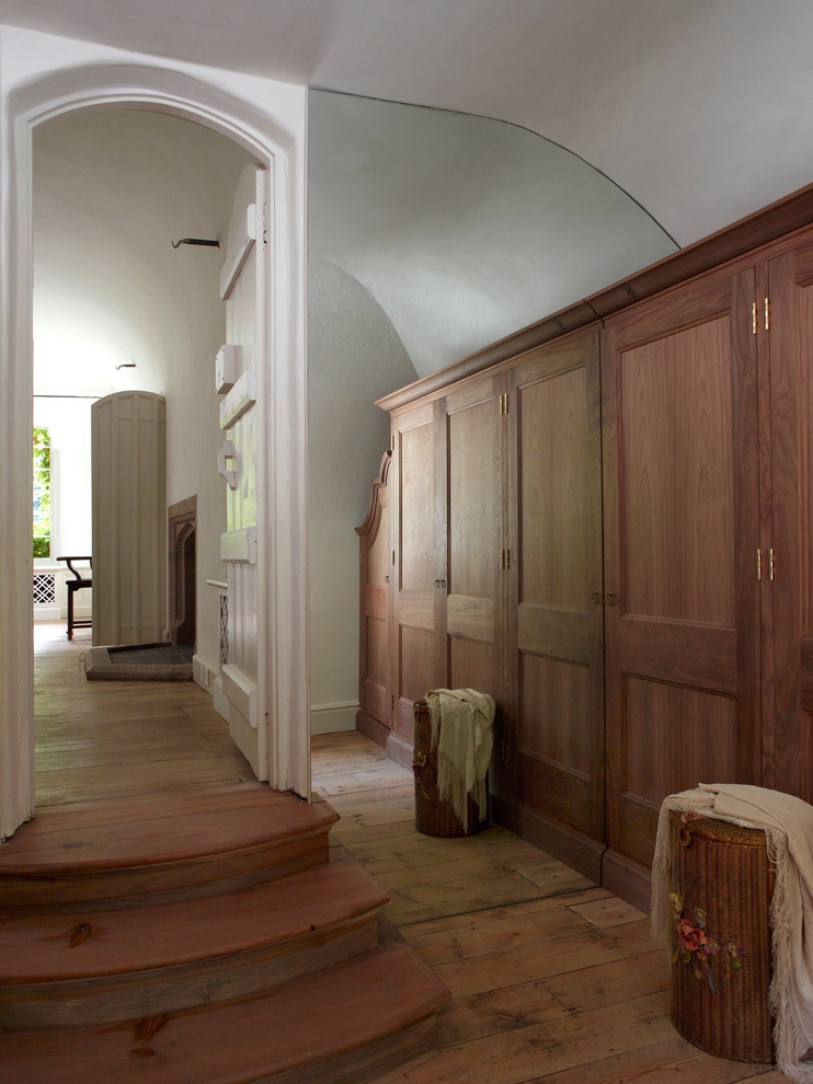 Idéer för mellanstora vintage omklädningsrum för könsneutrala, med luckor med infälld panel, skåp i mellenmörkt trä och mellanmörkt trägolv