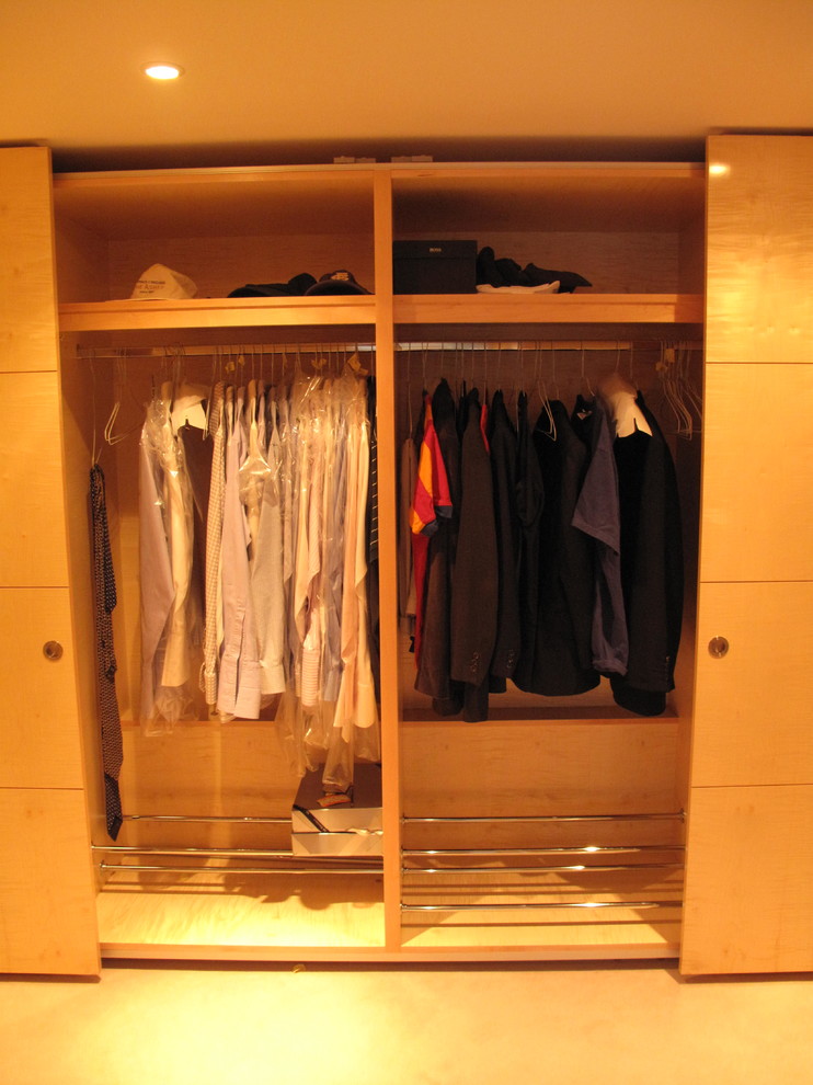 Immagine di un piccolo armadio o armadio a muro unisex minimalista con ante lisce, ante in legno chiaro e moquette