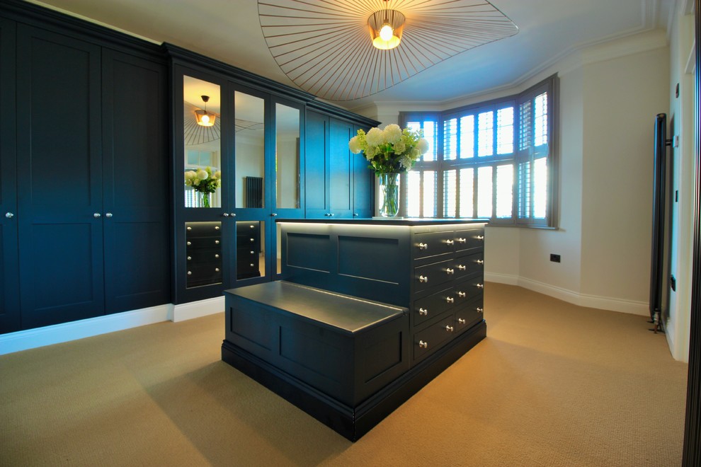 Идея дизайна: огромная гардеробная комната унисекс в современном стиле с фасадами в стиле шейкер, синими фасадами, ковровым покрытием и бежевым полом