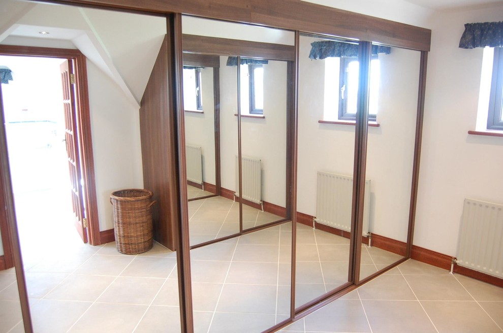 Idée de décoration pour un grand dressing room minimaliste en bois foncé neutre avec un sol en carrelage de porcelaine et un sol gris.