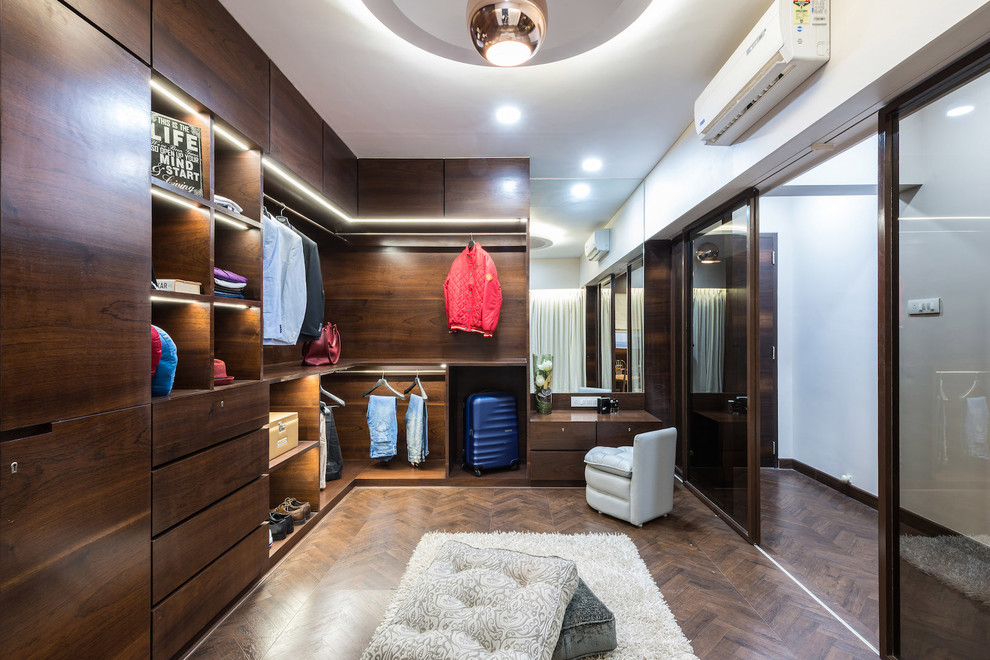 Exemple d'un dressing room tendance en bois foncé neutre avec parquet foncé et un sol marron.