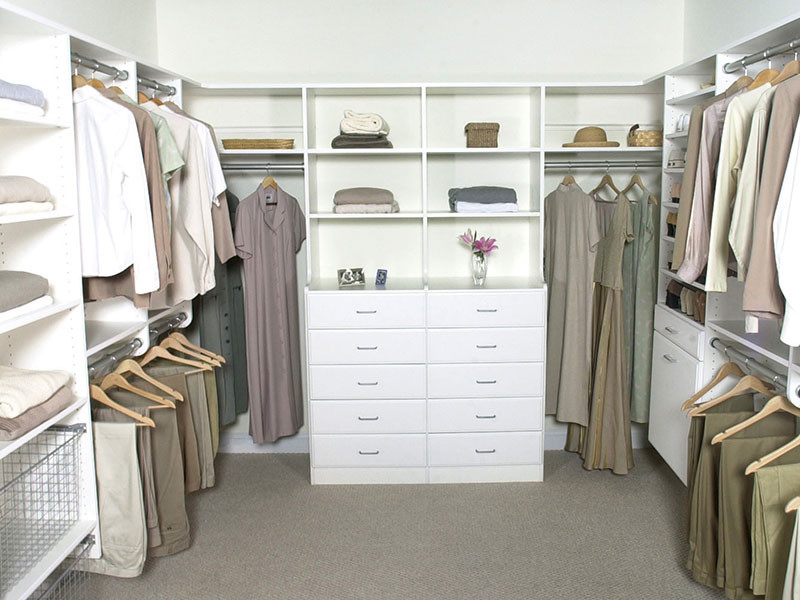 Ejemplo de armario vestidor unisex actual grande con armarios abiertos, puertas de armario blancas, moqueta y suelo beige