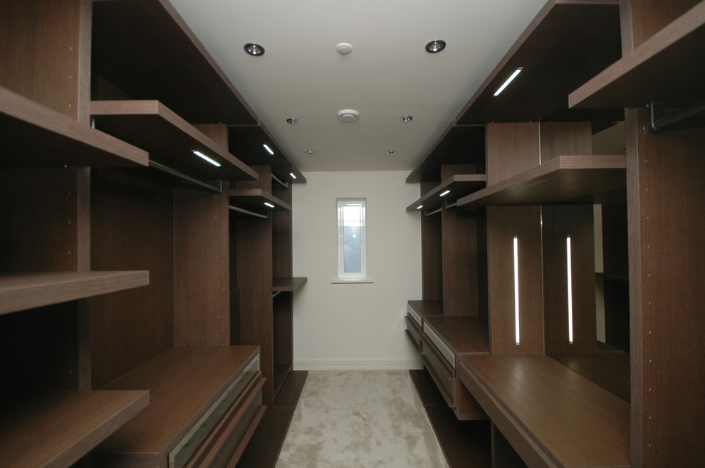Ispirazione per una cabina armadio design di medie dimensioni con ante in legno bruno