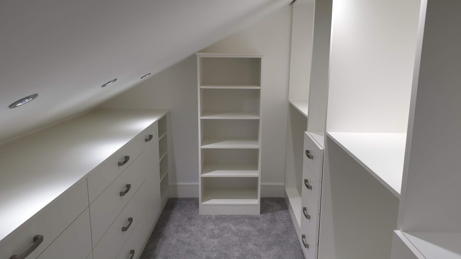 Modelo de armario vestidor unisex actual de tamaño medio con armarios con paneles lisos, puertas de armario blancas, moqueta y suelo gris
