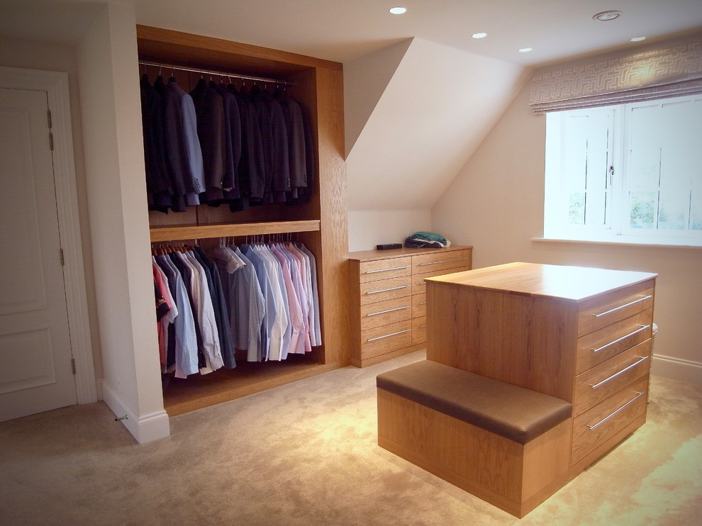 Ejemplo de armario vestidor actual grande con moqueta, armarios con paneles lisos y puertas de armario de madera oscura