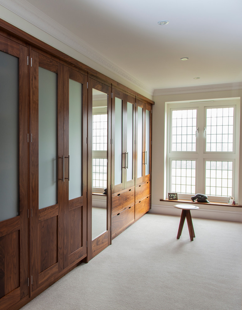 Стильный дизайн: большая гардеробная комната унисекс в стиле модернизм с ковровым покрытием - последний тренд