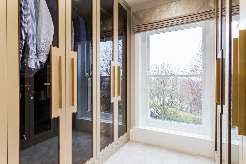 Exemple d'un dressing room moderne de taille moyenne et neutre avec un placard à porte vitrée, moquette et un sol gris.