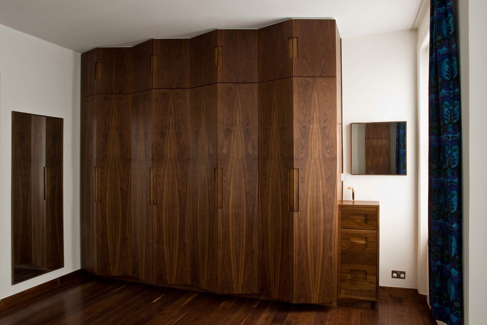 Idee per un grande armadio o armadio a muro unisex design con ante lisce, ante in legno bruno e parquet scuro
