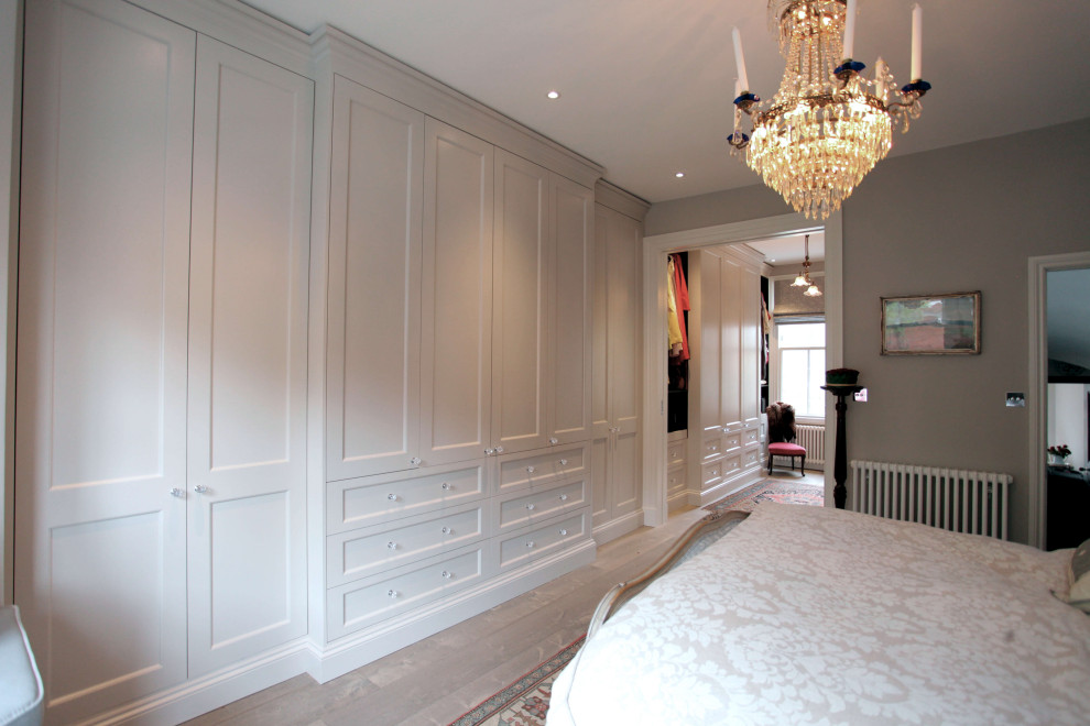 Foto de armario vestidor contemporáneo grande con suelo de madera clara y suelo beige