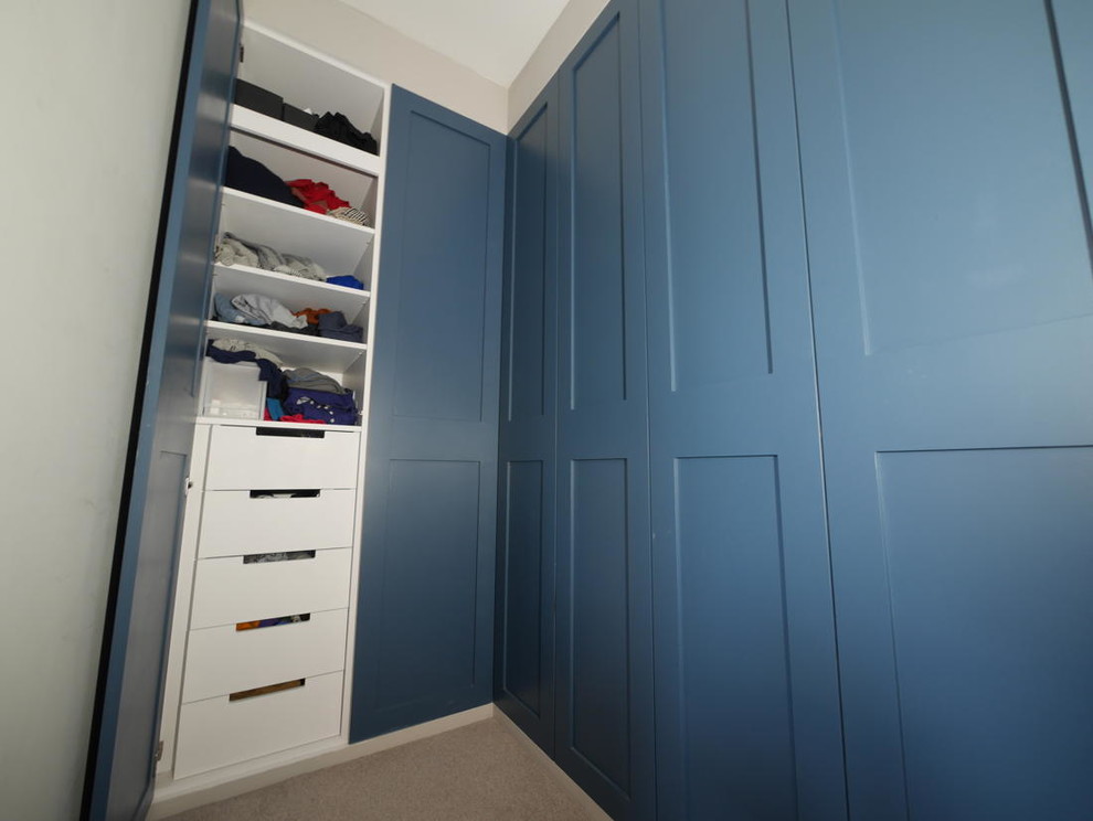 Imagen de armario unisex clásico de tamaño medio con armarios estilo shaker, puertas de armario azules y suelo de madera oscura