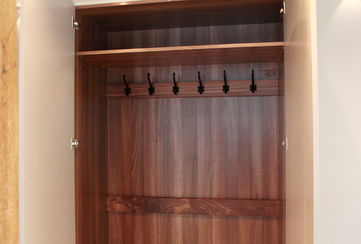 Photo of a medium sized contemporary wardrobe in London with flat-panel cabinets and white cabinets.