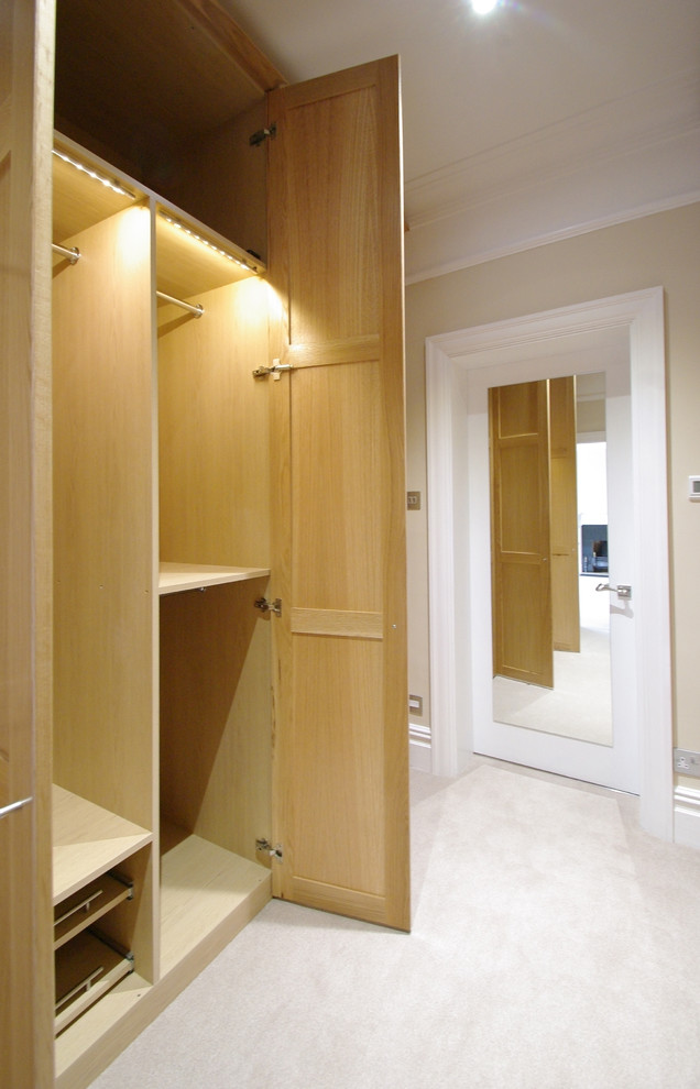 Inspiration for a medium sized modern gender neutral dressing room with shaker cabinets, medium wood cabinets and carpet.