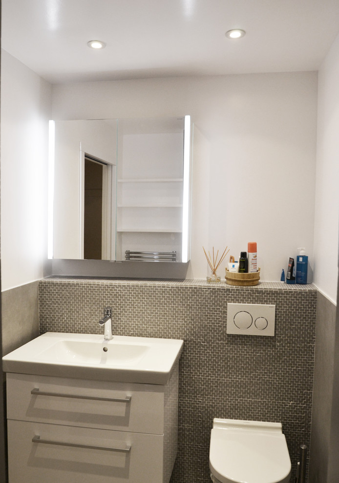 Esempio di un piccolo bagno di servizio design con WC sospeso, piastrelle in ceramica, pareti grigie, pavimento con piastrelle in ceramica, lavabo rettangolare e pavimento grigio