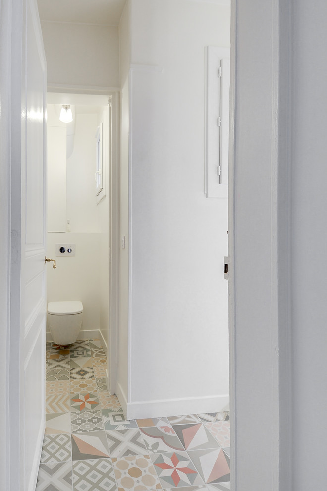 Kleine Klassische Gästetoilette mit Kassettenfronten, weißen Schränken, Wandtoilette, weißer Wandfarbe und Keramikboden in Paris