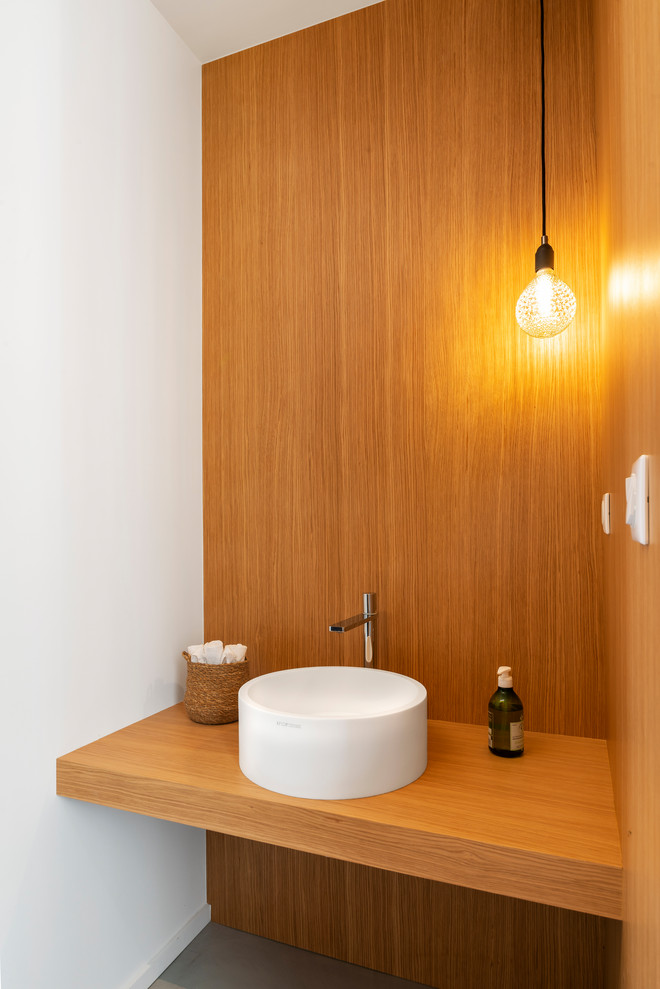 Idéer för funkis toaletter, med träbänkskiva, vita väggar, ett fristående handfat och grått golv