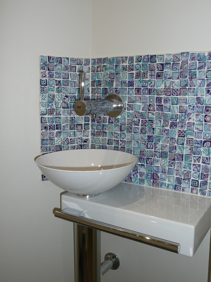 Example of a small trendy blue tile and mosaic tile ceramic tile powder room design in Paris with gray walls and a drop-in sink