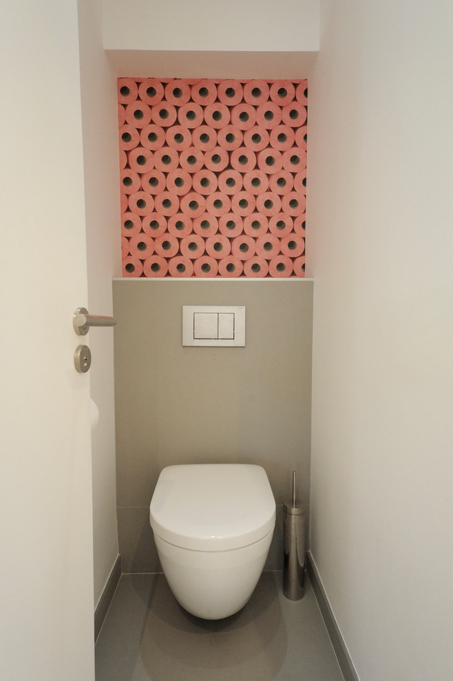 Immagine di un piccolo bagno di servizio minimal con consolle stile comò, WC sospeso, pareti grigie e pavimento grigio
