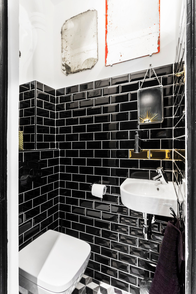 Idées déco pour un petit WC suspendu contemporain avec un lavabo suspendu, un carrelage métro et un mur noir.